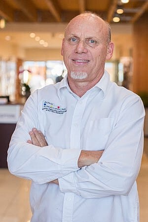 Man with crossed arms in a professional setting.