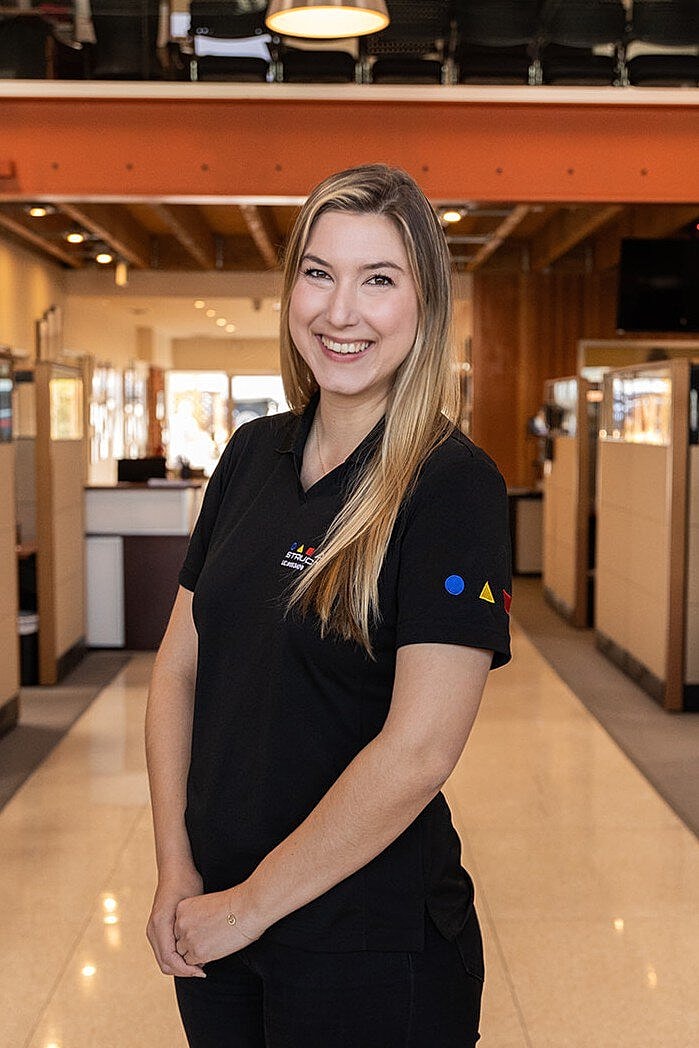 Smiling woman in a black polo shirt.