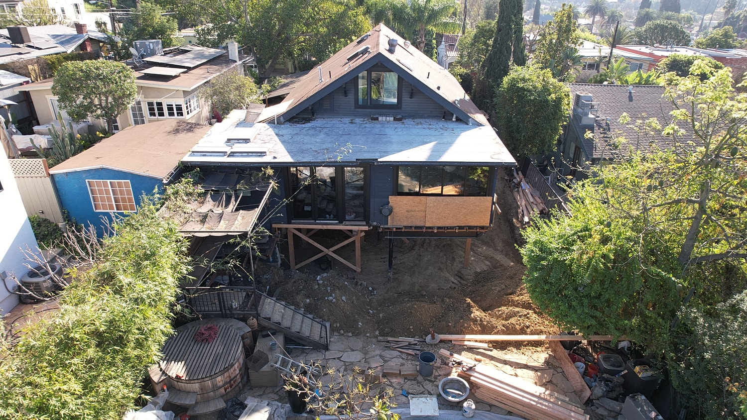 Modern house under construction with surrounding greenery.
