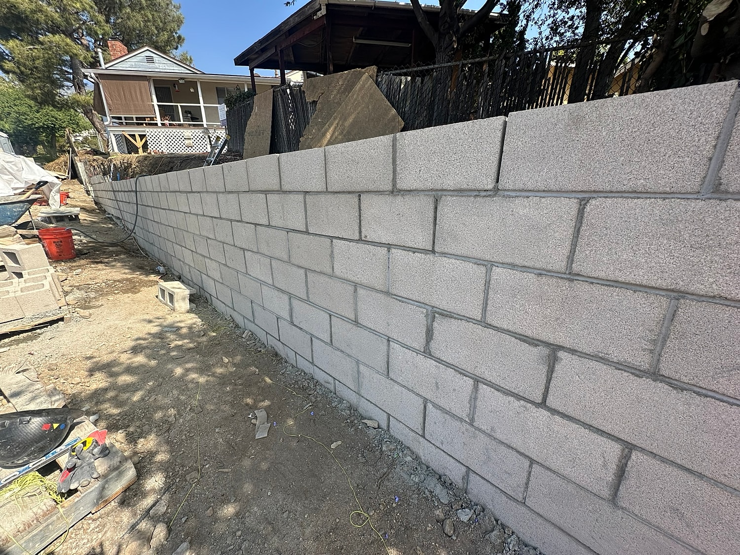 Concrete block wall under construction in backyard.