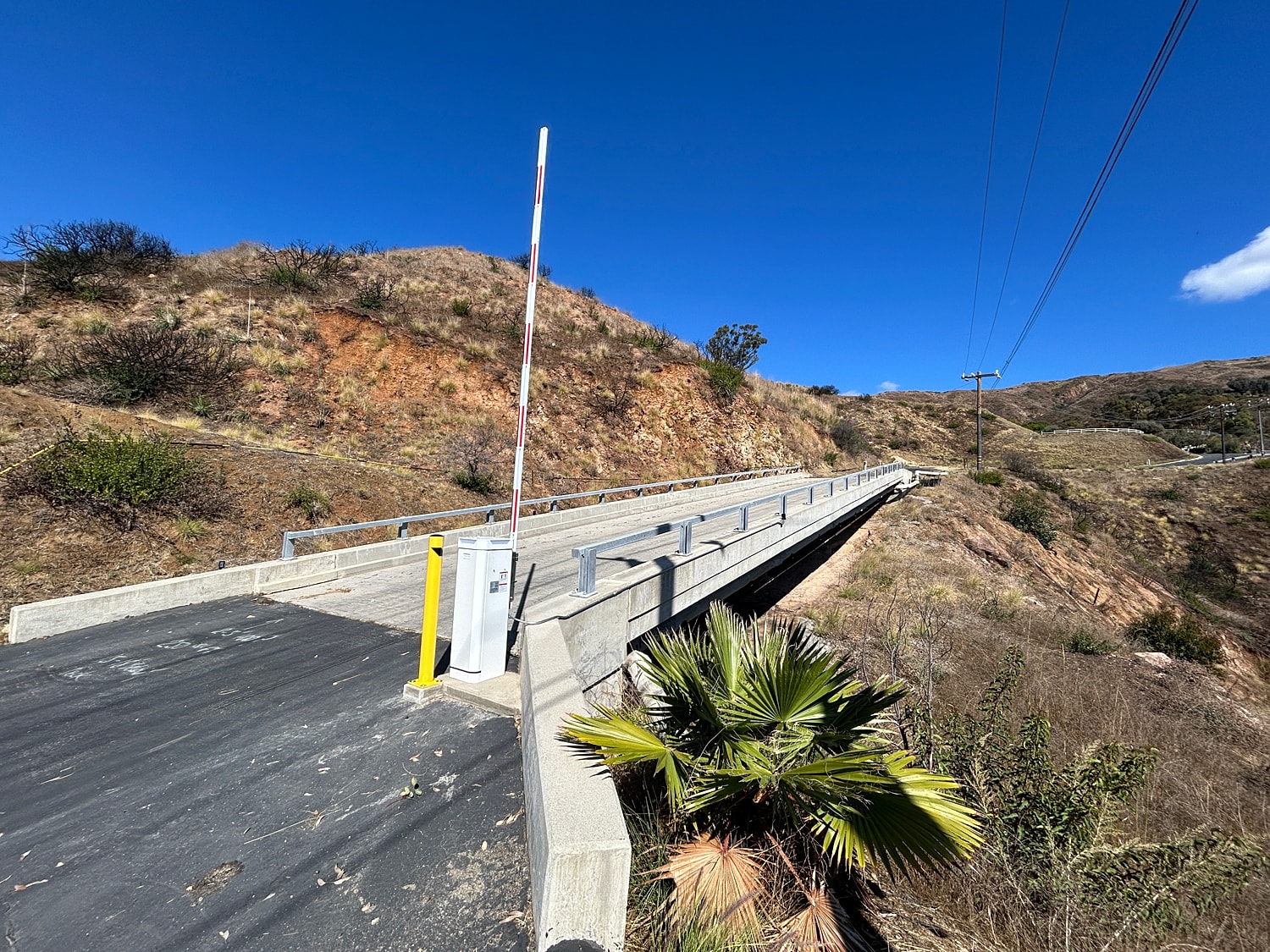 Bridge on hillside under clear blue sky.