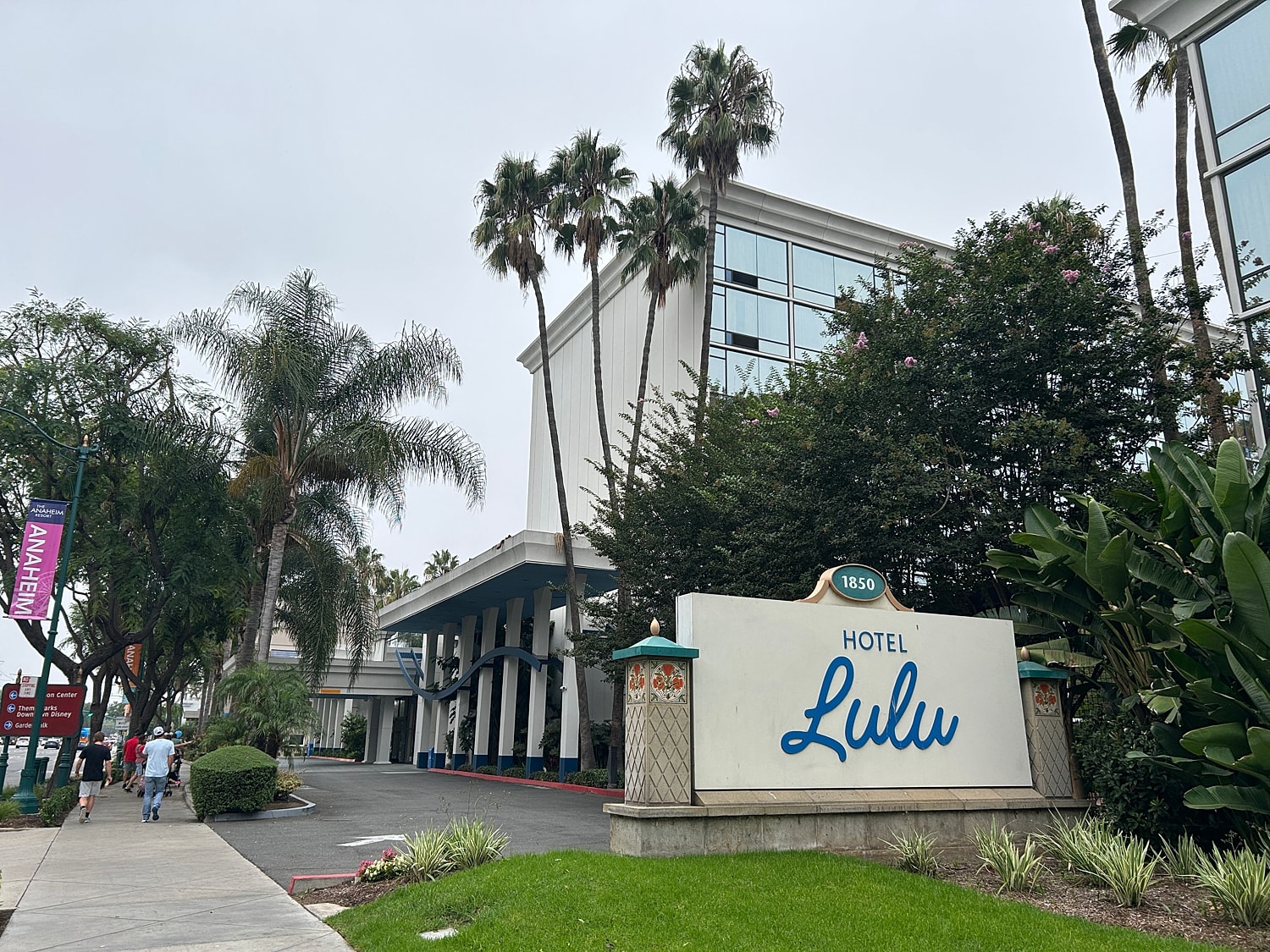Hotel Lulu entrance with palm trees and greenery.