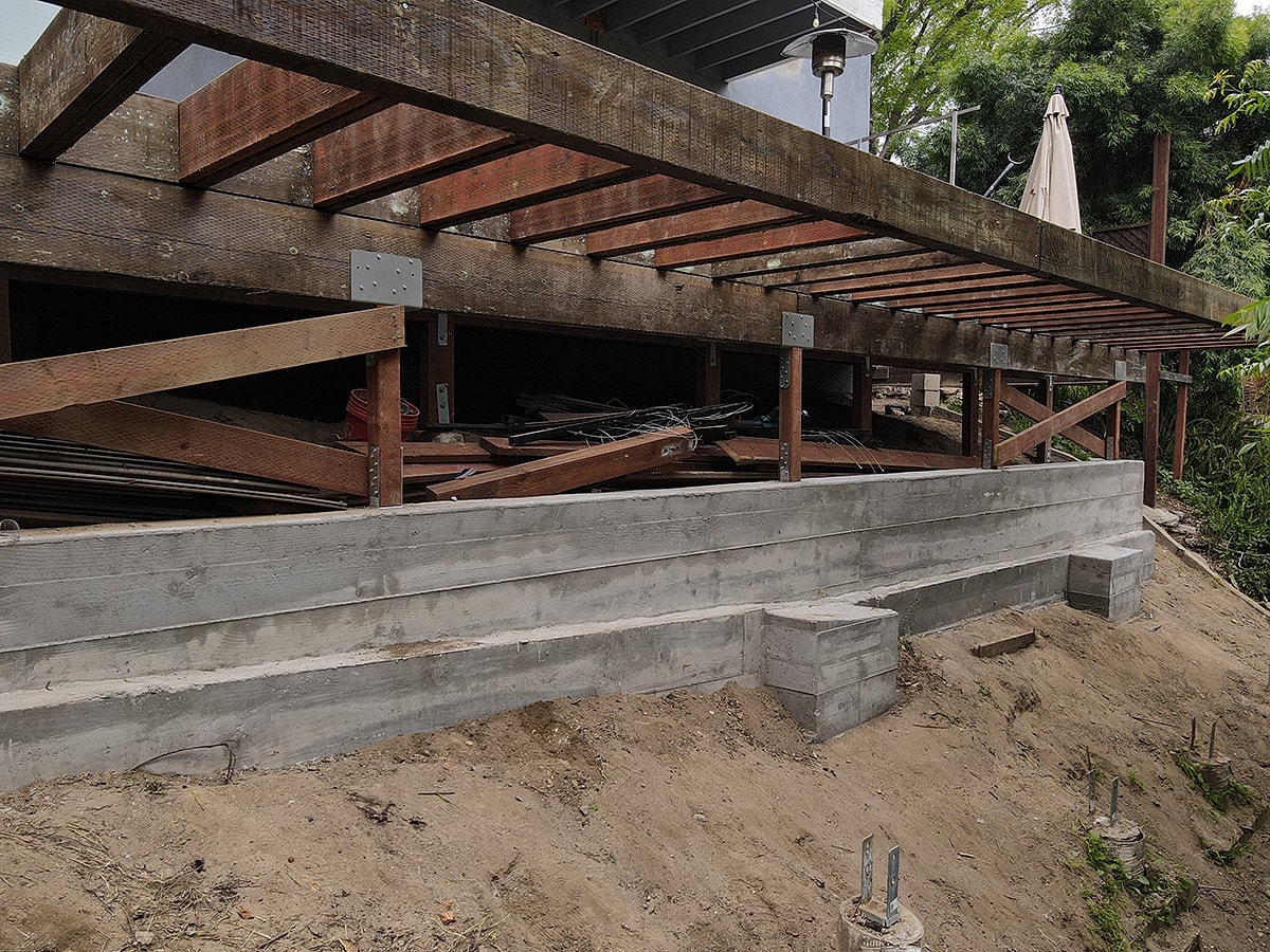 Under-construction wooden deck with concrete foundation.
