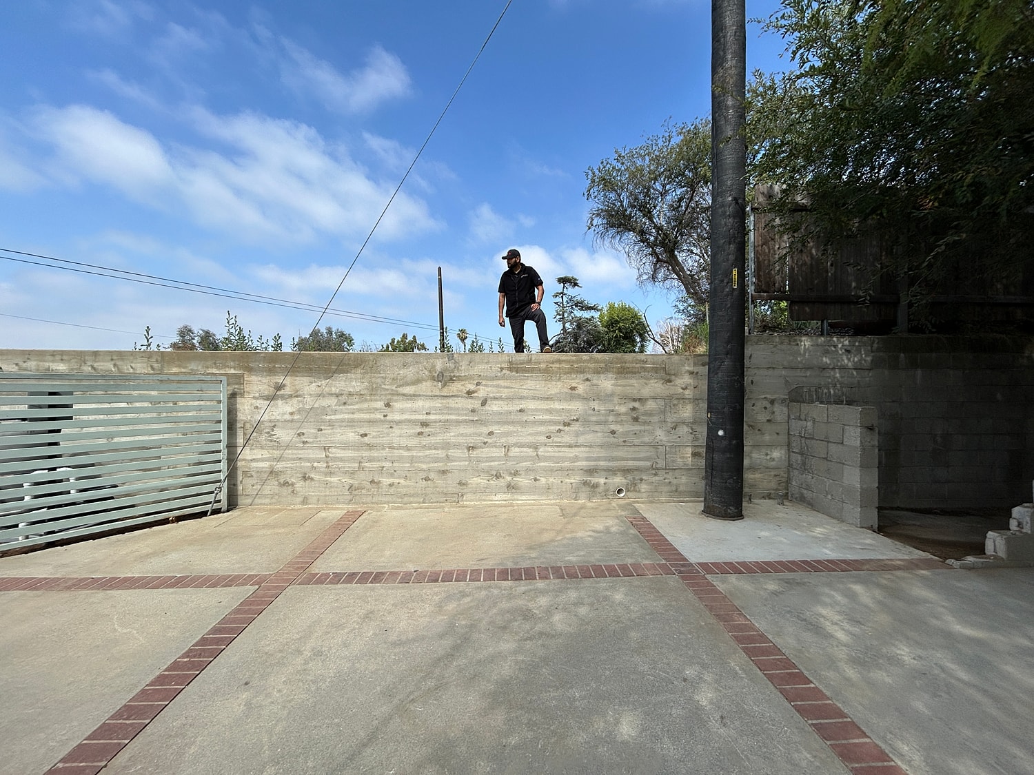 Person standing on a concrete wall outdoors.