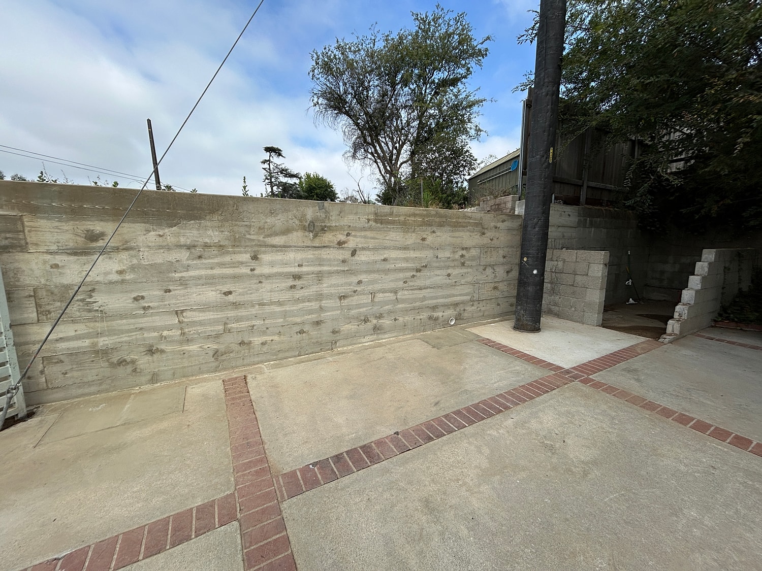 Outdoor space with wall and concrete flooring.