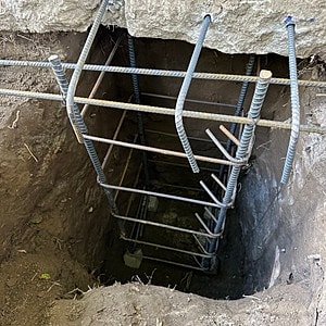 Reinforced ladder inside a deep excavation site.