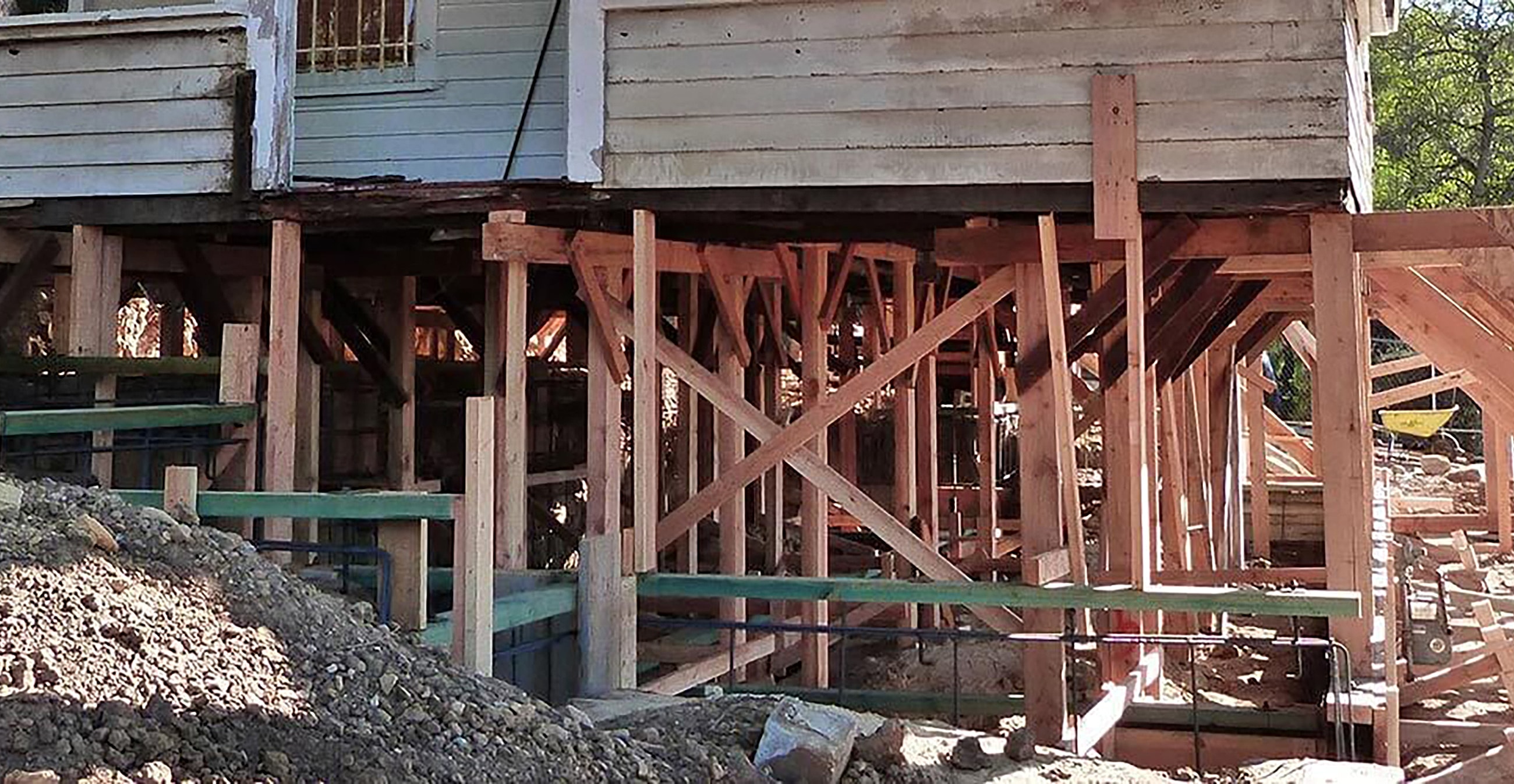 House raised on wooden supports during renovation.
