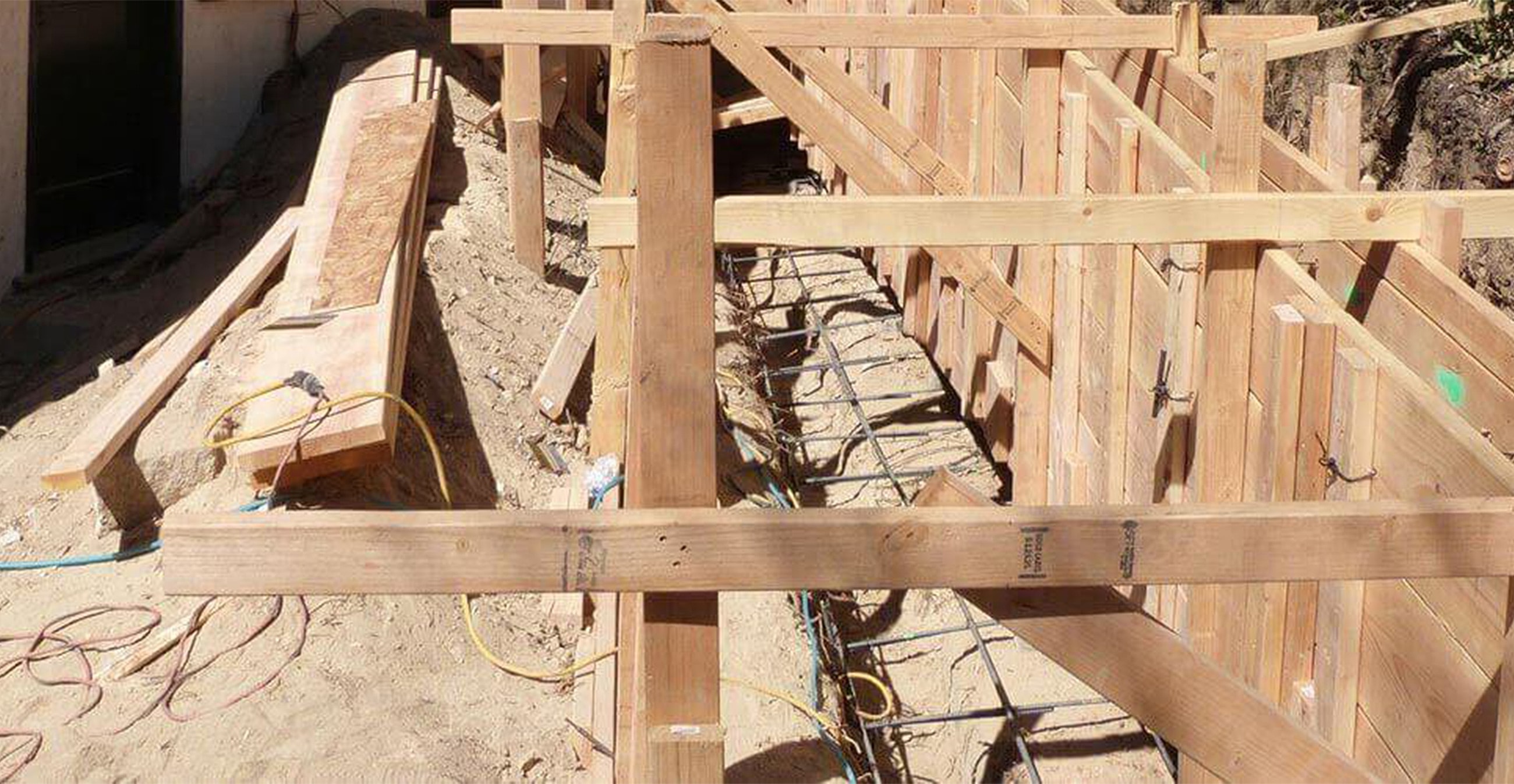 Construction site with wooden framework and materials.