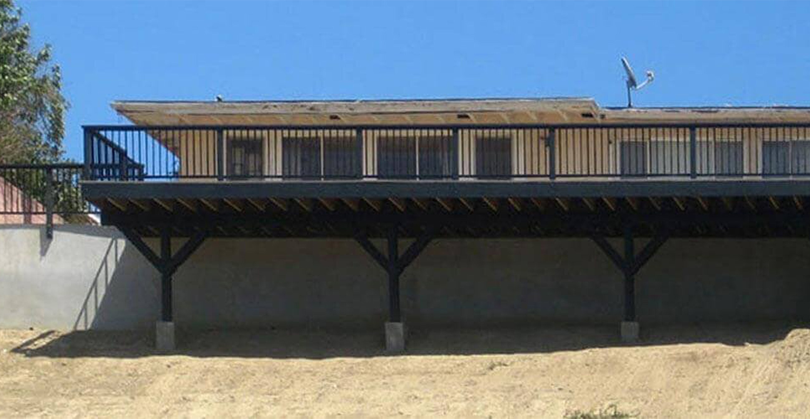 Raised building with balcony and satellite dish.