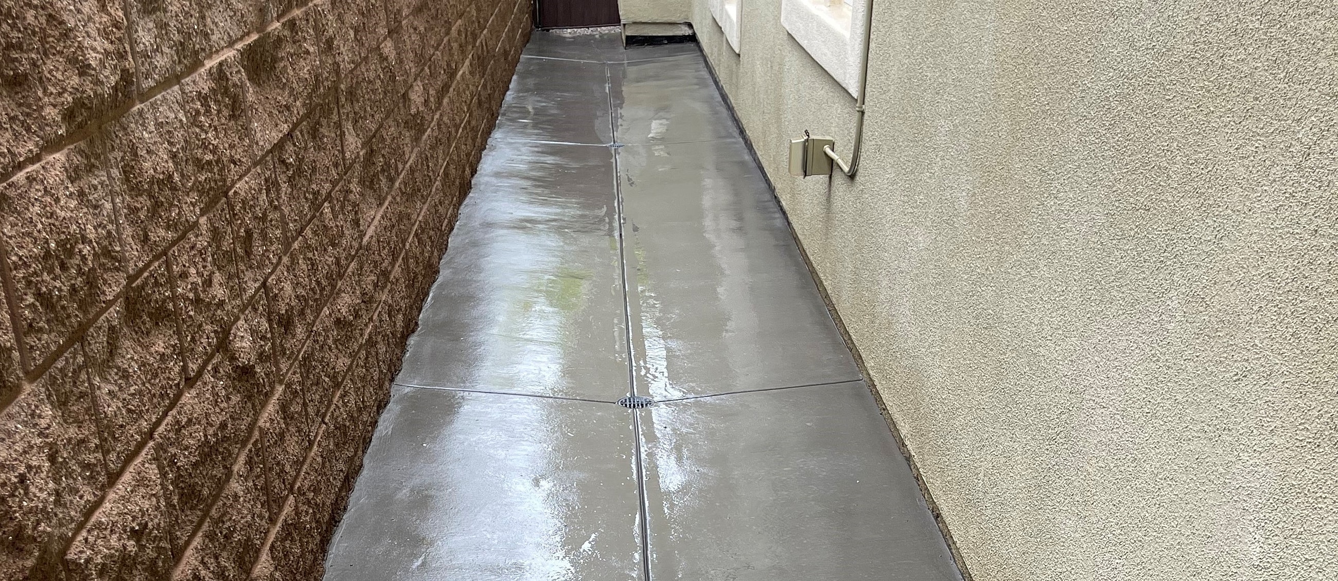 Narrow walkway between two buildings after rain.