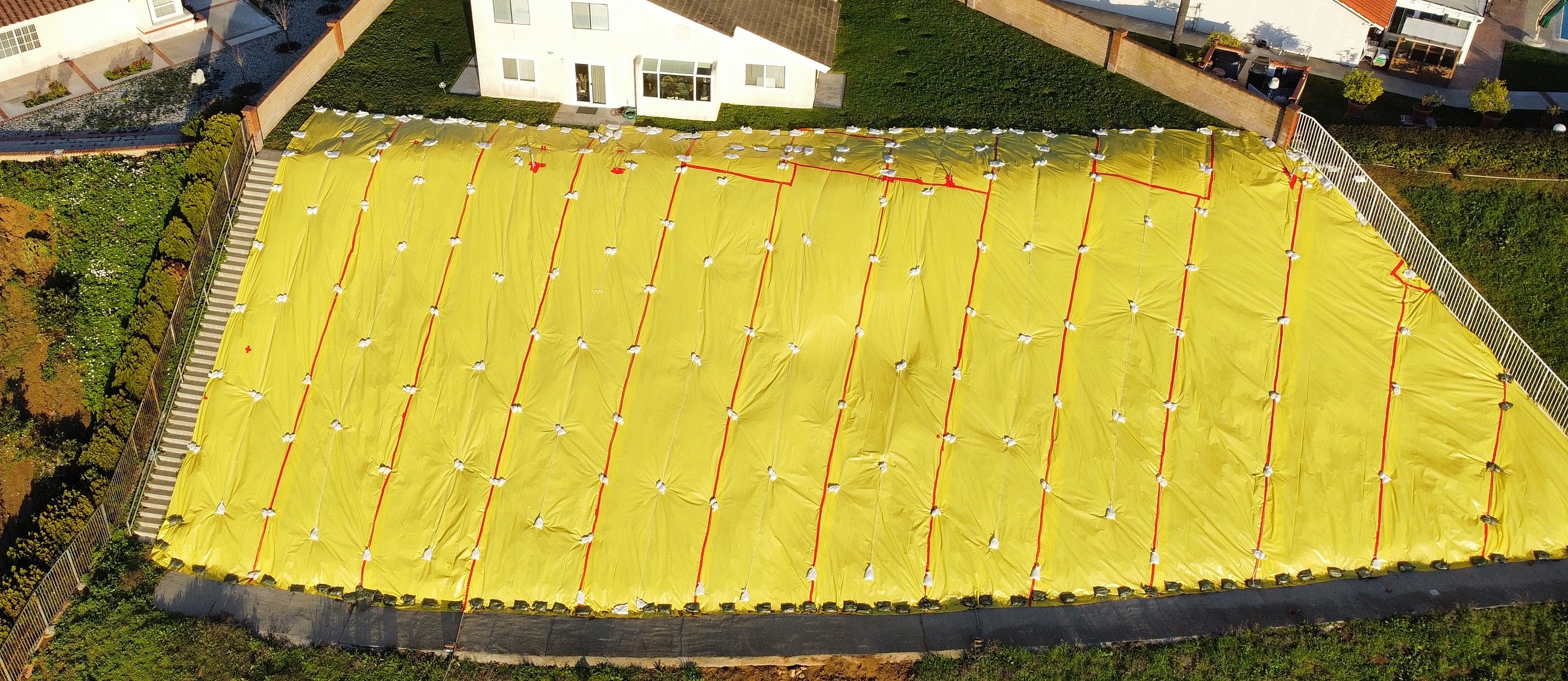 Yellow tarps covering hillside for landscaping or protection.