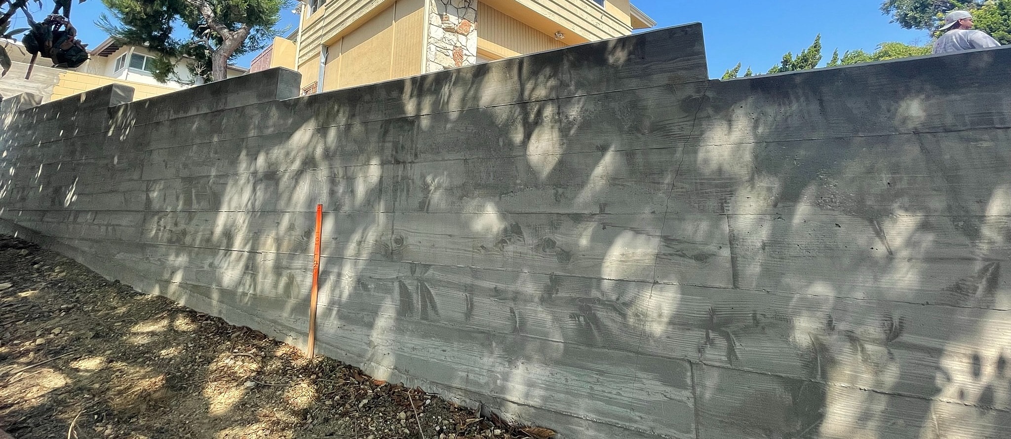 Concrete wall with shadows and orange marker